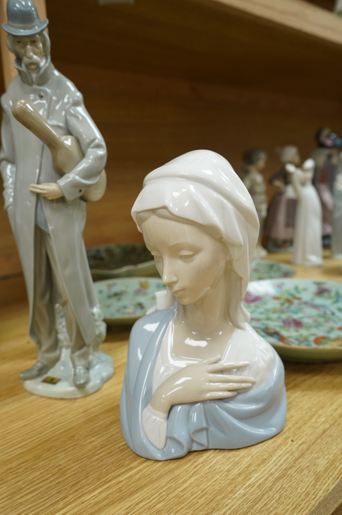 A group of Lladro figures: Tramp with violin, Bust of Mary Magdalene, Holy family, Girl with child, Young Shepherds, Girl with basket, girl with jug
